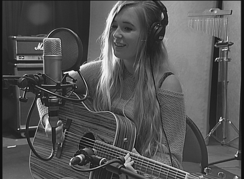 lily fearn with guitar singing into mic